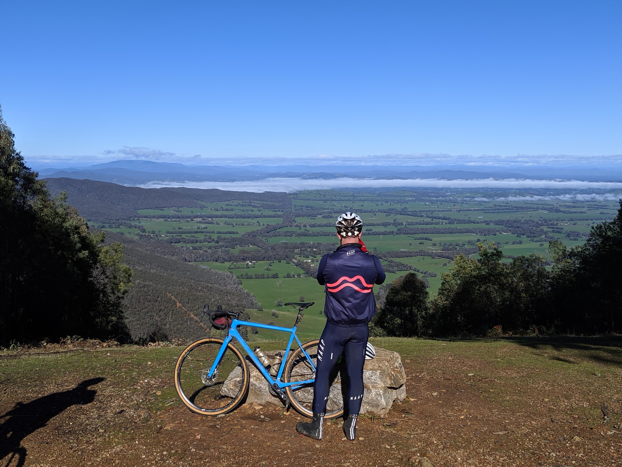 A gravel cyclists taking a photo at a lookout near Beechworth