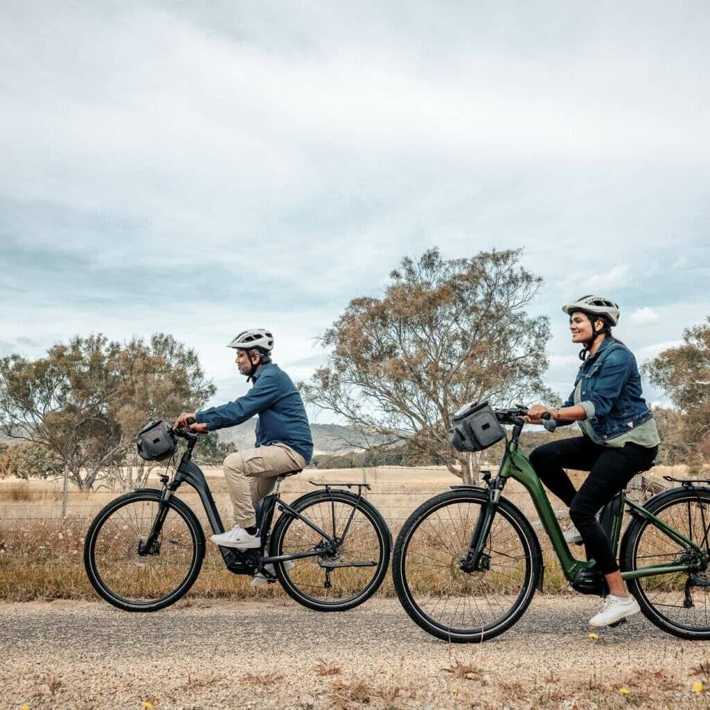 Couple riding past rural views and gum trees on the Beechworth to Yackandandah Rail Trail